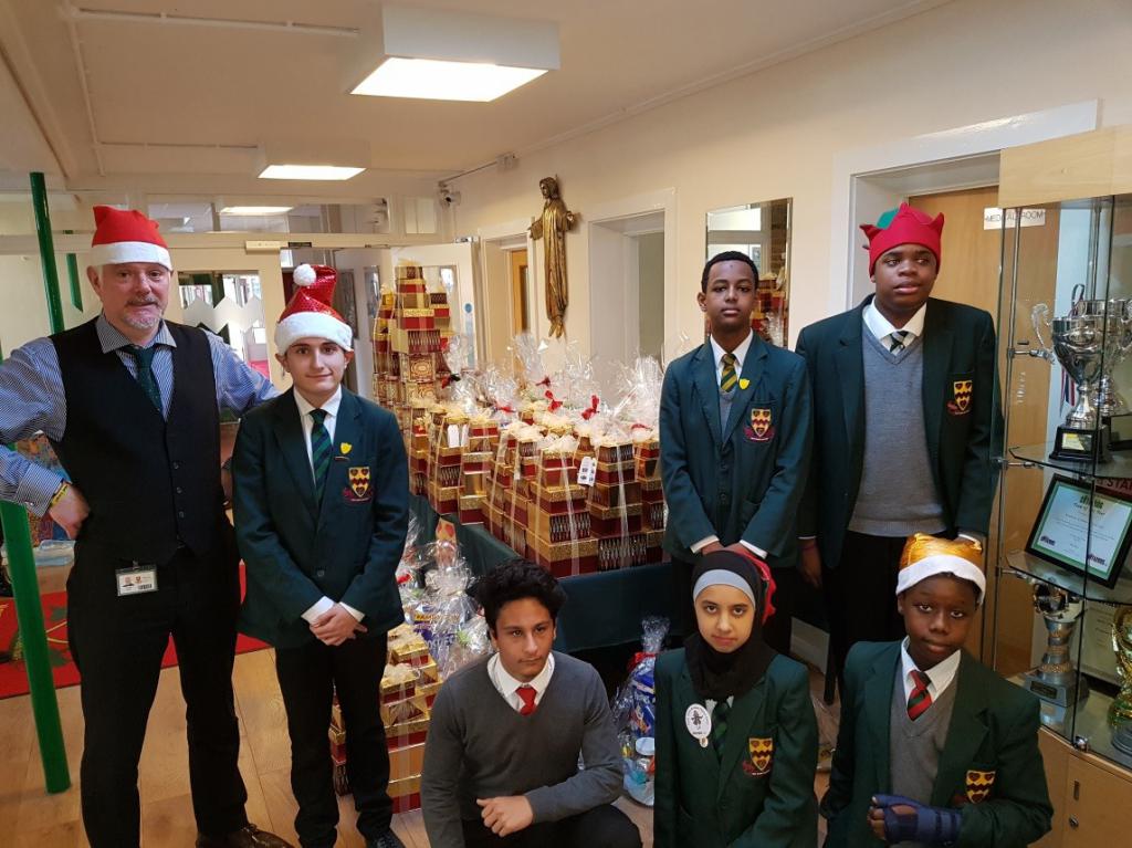 Headteacher Danny Coyle with some students in front of the assembled gifts.